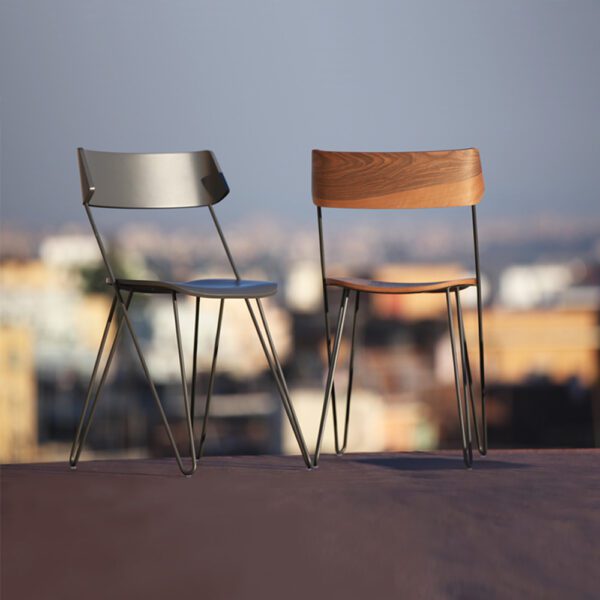 Sedia Ibsen One grigia antracite di Greyge, che mette in risalto i suoi braccioli slanciati e il design minimalista con legno curvato laccato e una struttura in acciaio raffinata.